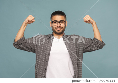 Portrait of bearded strong pride handsome man with black glasses in casual style looking at camera and smiling. studio shot on blue background. 89970334