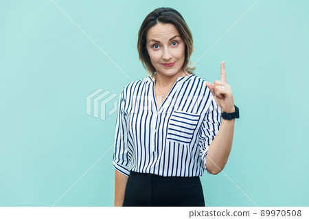 Shame of you! Cute business woman worker lady pointing finger up and smiling face. Light blue background Shame of you! Cute business woman worker lady pointing finger up and smiling face. Light blue background 89970508