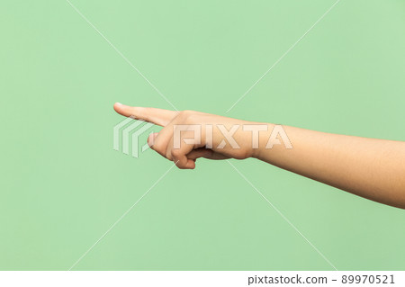 Look this! Hand finger pointing isolated on green background. Studio shot 89970521