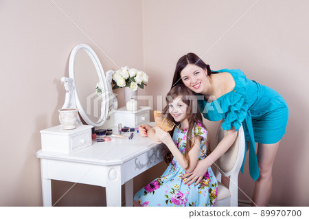 Mother hairdressing her preteen beautiful daughter at home. 89970700