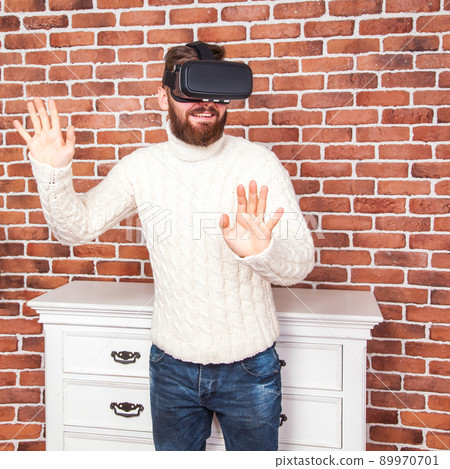 loneliness and illusion of new year. the portrait of bearded man with virtual reality glasses near new year's tree. 89970701