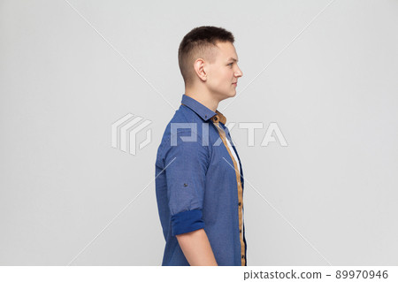 Profile young boy. Standing near gray wall Profile young boy. Standing near gray wall 89970946