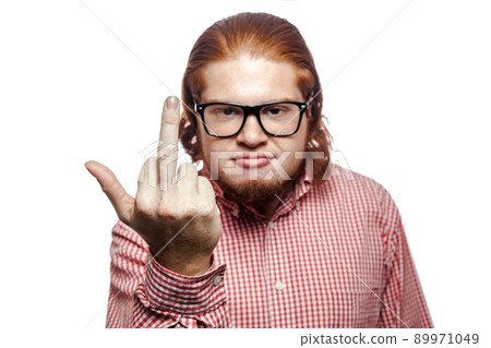Angry bearded readhead businessman with red shirt and freckles looking at camera and showing middle finger . studio shot isolated on white. 89971049