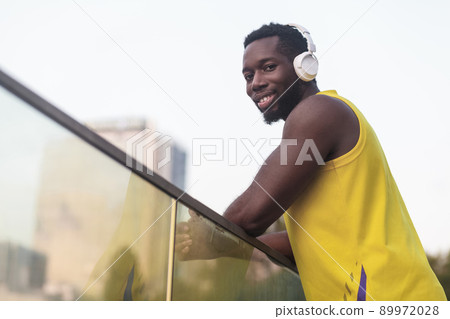 Portrait of handsome black skinned man, listen music after workout. Blurred background. Outdoor shot, morning. Spring or summer Portrait of handsome black skinned man, listen music after workout. Blurred background. Outdoor shot, morning. Spring or summer 89972028