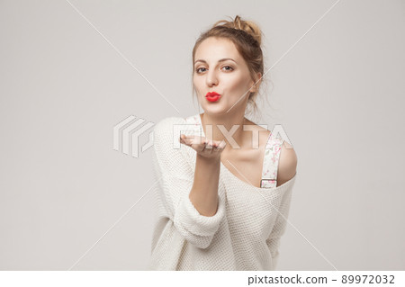 Romantic woman send air kiss at camera. Studio shot, isolated on gray background Romantic woman send air kiss at camera. Studio shot, isolated on gray background 89972032