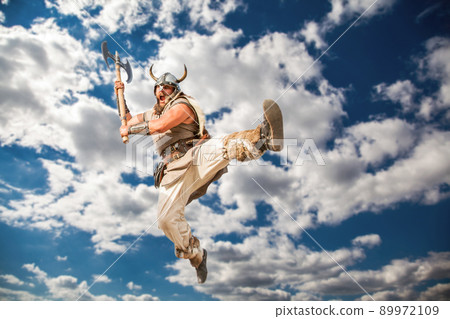 crazy strong viking with traditional costume attacking from sky. looking at camera with angry eyes. 89972109