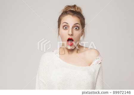 Amazement blonde open mouth and scream with surprised face. Studio shot, gray background 89972146