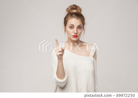 Teacher blonde woman finger up and looking seriously at camera. Studio shot, isolated on gray background Teacher blonde woman finger up and looking seriously at camera. Studio shot, isolated on gray background 89972250