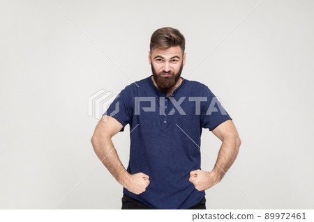 Popeye the Sailor style. Masculinity and strong bearded man posing and looking seriously at camera. Studio shotm gray background 89972461