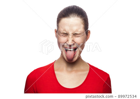 Portrait of crazy funny woman in red t-shirt with freckles and tongue. closed eyes, studio shot. isolated on white background. 89972534