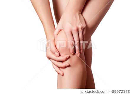 Closeup view of a young woman with knee pain on white background. 89972578