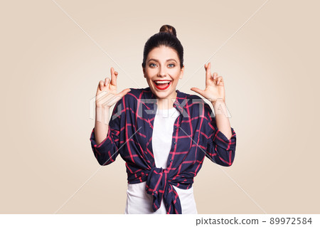 Portrait of beautiful girl in casual style looking at camera with liar pose laughing. studio shot on beige background. Portrait of beautiful girl in casual style looking at camera with liar pose laughing. studio shot on beige background. 89972584