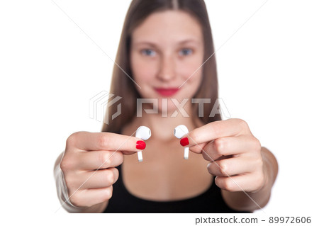 Young beautiful woman with freckles and wireless earphones on her ears. studio shot. 89972606