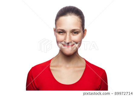 Portrait of satisfied funny woman in red t-shirt with freckles. looking at camera, studio shot. isolated on white background. 89972714