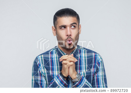 Meannes man have a idea or bad plan. Looking away and crossed hands . Isolated on gray background Meannes man have a idea or bad plan. Looking away and crossed hands . Isolated on gray background 89972720