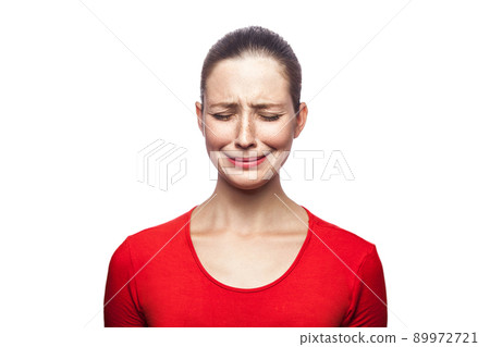 Portrait of sad unhappy crying woman in red t-shirt with freckles. closed eyes, studio shot. isolated on white background. Portrait of sad unhappy crying woman in red t-shirt with freckles. closed eyes, studio shot. isolated on white background. 89972721