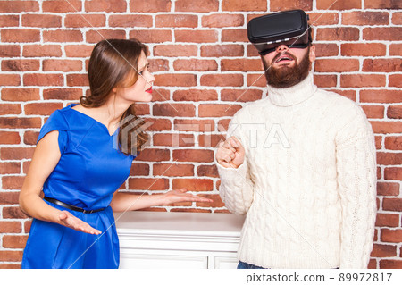 VR technology and conflict between couple. man using vr headset and his wife is angry. 89972817
