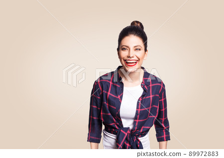 Portrait of beautiful laughing happy girl in casual style looking at camera and laughing. studio shot on beige background. 89972883