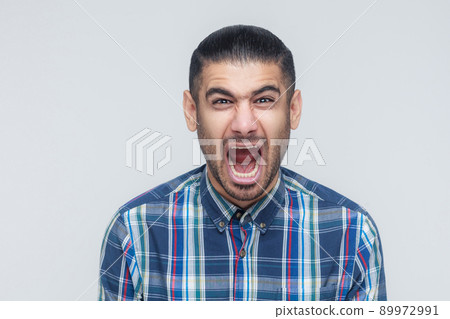 Mans roar! The angry businessman, screaming with closed eyes. Indoor, studio shot. Gray background Mans roar! The angry businessman, screaming with closed eyes. Indoor, studio shot. Gray background 89972991