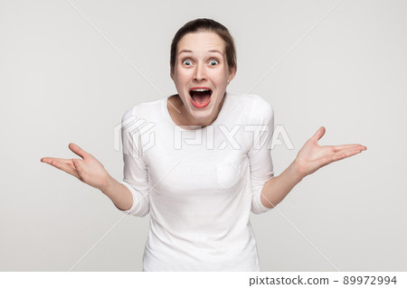 Wow. Woman open mouth and looking at camera with open mouth and big eyes. Studio shot, gray background Wow. Woman open mouth and looking at camera with open mouth and big eyes. Studio shot, gray background 89972994