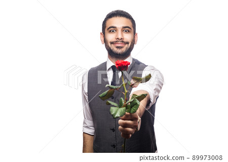 Handsome romantic happy man with rose flower. studio shot. isolated on white background. holding and giving flower and looking at camera and smiling.. 89973008