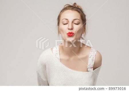 Closeup portrait of romantic woman send air kiss at camera. Studio shot, isolated on gray background Closeup portrait of romantic woman send air kiss at camera. Studio shot, isolated on gray background 89973016