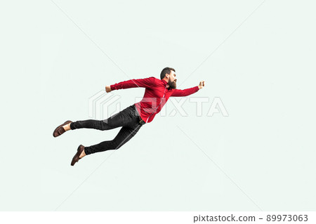 Superman style. Enthusiasm concept. strong bearded businessman felt himself a superhero and flying up. indoor studio shot isolated on gray background. 89973063