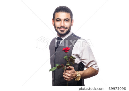 Handsome romantic happy man with rose flower. studio shot. isolated on white background. holding and giving flower and looking at camera and smiling.. 89973098