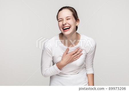 Funny concept. Expressing young adult freackles woman toothy smiling. Studio shot, isolated on gray background 89973206