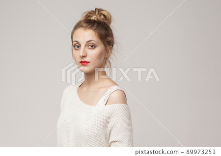 Portrait of cute georgian woman, looking at camera with relax face. Studio shot, gray background 89973251