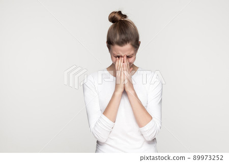 Dramatic young girl crossed hands and cry. Studio shot,isolated on gray background Dramatic young girl crossed hands and cry. Studio shot,isolated on gray background 89973252