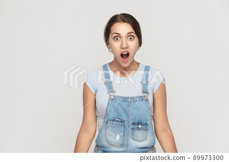 Wow! Portrait of cute woman with shocked facial expression. Studio shot, gray wall Wow! Portrait of cute woman with shocked facial expression. Studio shot, gray wall 89973300