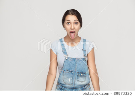 Happiness asian woman with big eyes and tongue out. Indoor shot on gray background studio shot 89973320