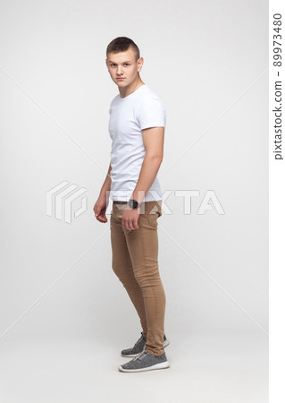Full height young boy standing near gray wall and looking at camera. Studio shot Full height young boy standing near gray wall and looking at camera. Studio shot 89973480