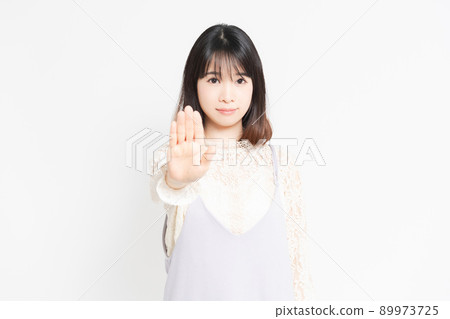 Young woman posing NG in front of white background Young woman posing NG in front of white background 89973725