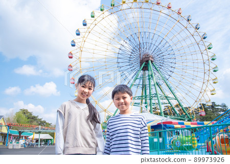 Elementary school boys and girls playing in an amusement park 89973926