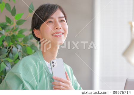 A woman who puts her smartphone in front of her chest and fantasizes about having fun 1 89976714