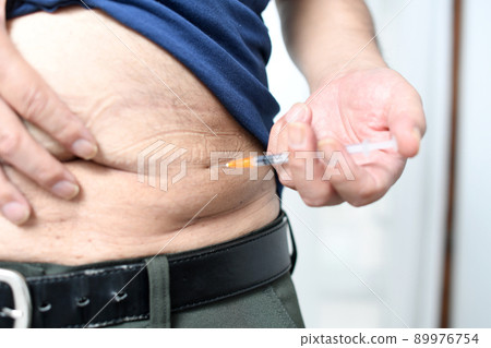 Image of hitting an insulin injection in the abdomen Image of hitting an insulin injection in the abdomen 89976754