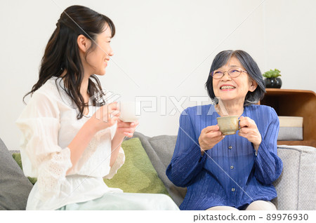 Also for the main visual! Elderly mother and daughter relaxing in the living room Also for the main visual! Elderly mother and daughter relaxing in the living room 89976930