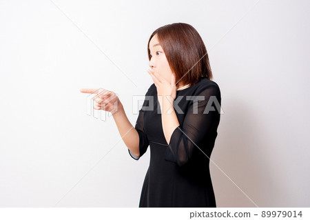 A woman wearing a mourning dress pointing in amazement A woman wearing a mourning dress pointing in amazement 89979014