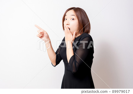 A woman wearing a mourning dress pointing in amazement 89979017