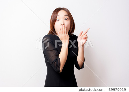 A woman wearing a mourning dress pointing in amazement 89979019