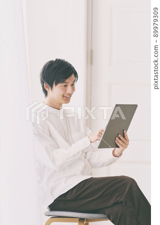 Male portrait looking at a tablet Casual Male portrait looking at a tablet Casual 89979309