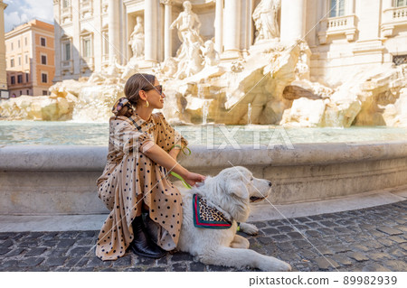 Woman with dog near famous di Trevi fountain in Rome 89982939
