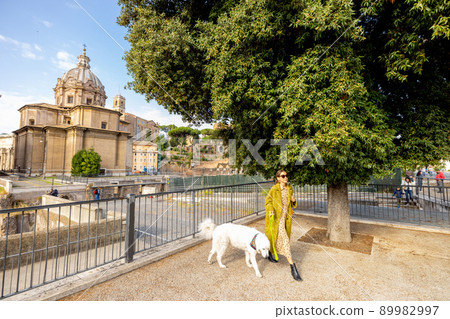 Woman walks with her dog in the centre of Rome 89982997