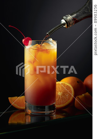 Tequila Sunrise alcoholic cocktail in a tall glass. Tequila Sunrise alcoholic cocktail in a tall glass. 89983256