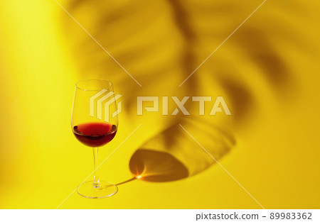 Glass of red wine on a yellow background. Glass of red wine on a yellow background. 89983362