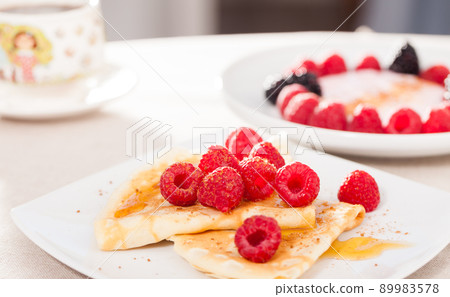 breakfast of pancakes with fresh raspberries on table breakfast of pancakes with fresh raspberries on table 89983578