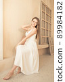 young girl in white dress sits and poses 89984182