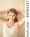 young girl with fingers in her hair, looking at camera 89984187